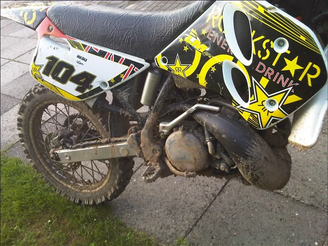 A KTM motorcycle with NEBU on the side graphics and racing number 104.