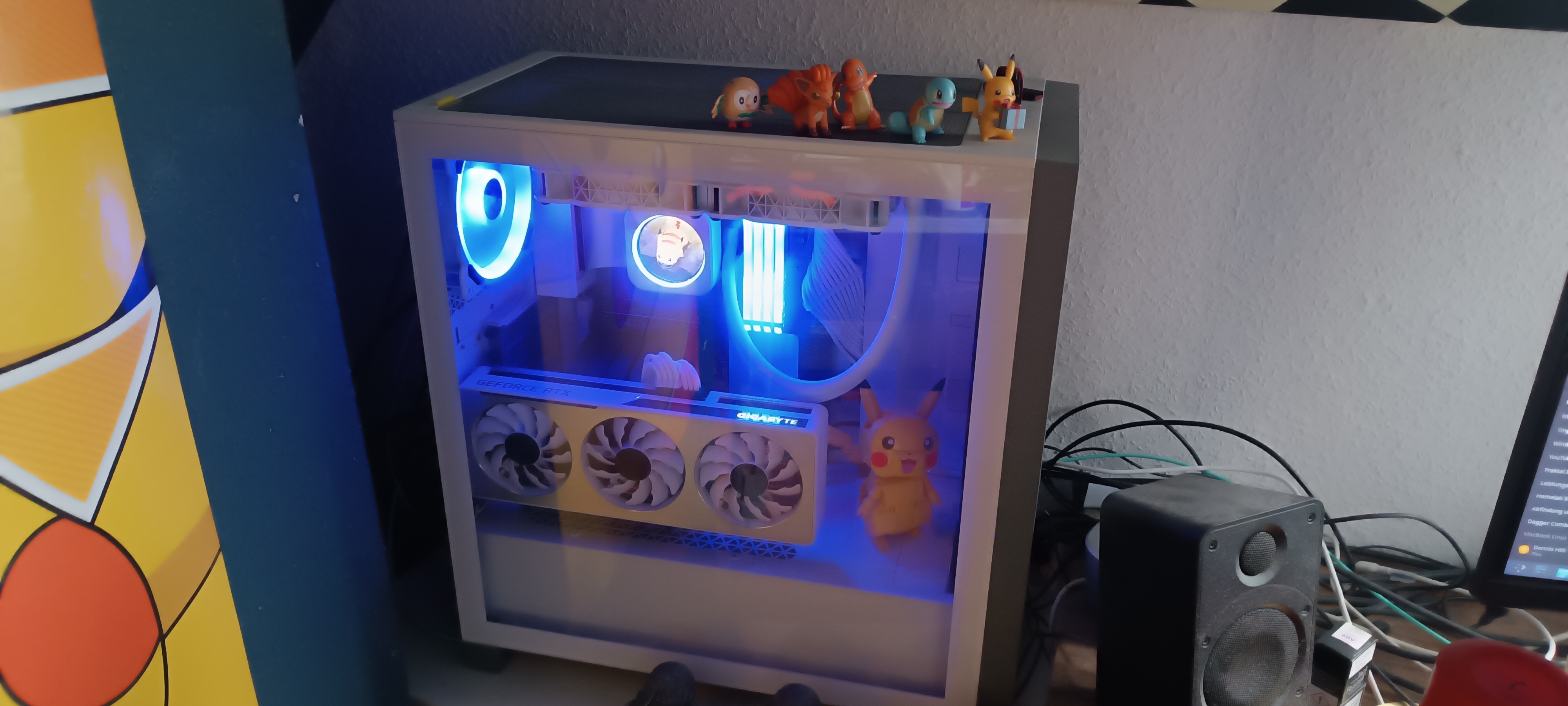 A deliberately personalized modern desktop computer with blue lighting, visible cooling hardware, and small figures on top.