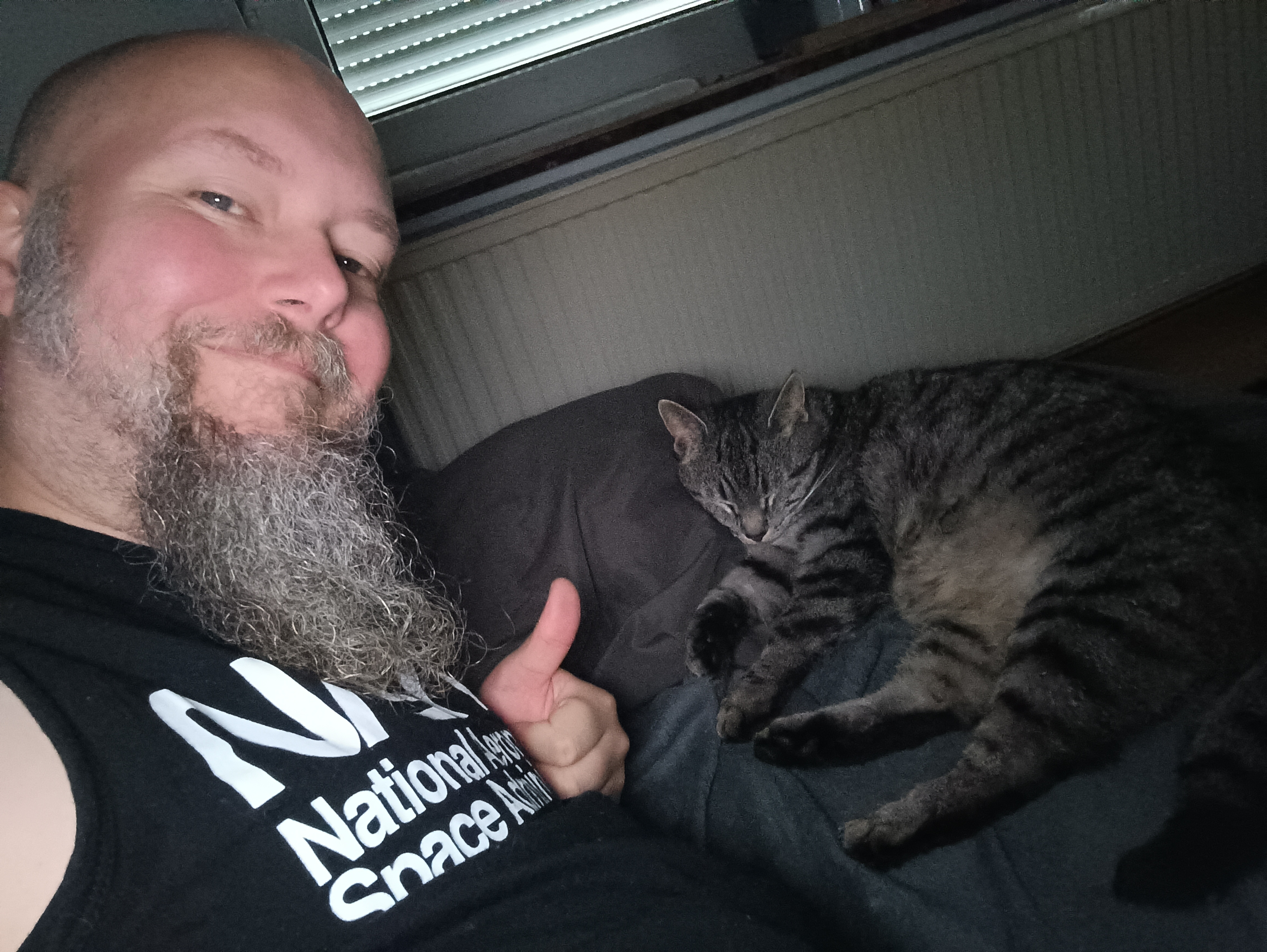 Dennis Hilk beside a sleeping tabby cat.